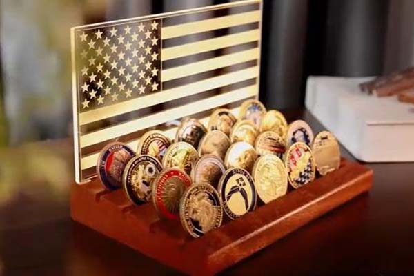 A wooden display holder for challenge coins, with multiple slots for organizing and showcasing various coins.