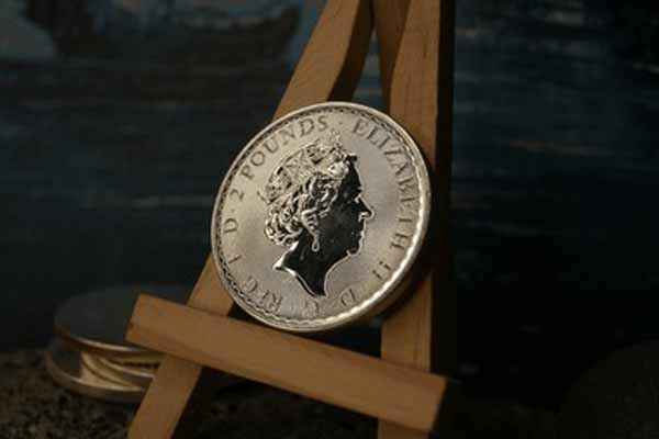 Silver coin featuring Queen Elizabeth II on a wooden display stand