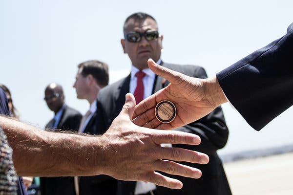 A Presidential Challenge Coin being presented during a award ceremony.