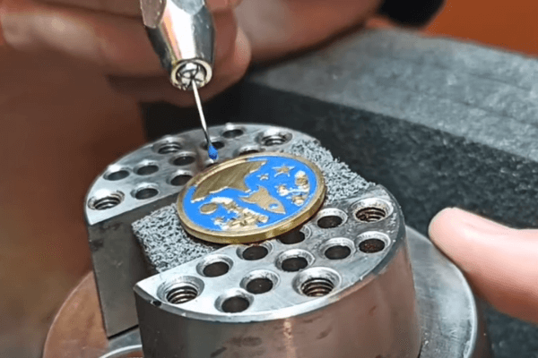 Applying enamel paint on a metal badge